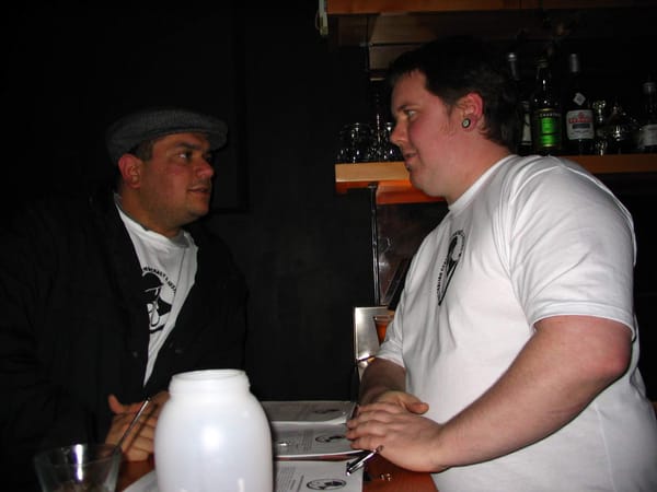 Terry and Hammy both leaning on opposite sides of a counter, deep in discussion.